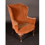 A George II design mahogany wing back armchair, outswept arms, stuffed-over upholstery,