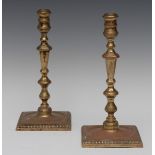 A pair of George III design brass table candlesticks, waisted sconces, knopped stems,