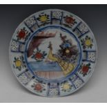 A Delft circular dish, painted in polychrome, with peacock and stylised flowers,