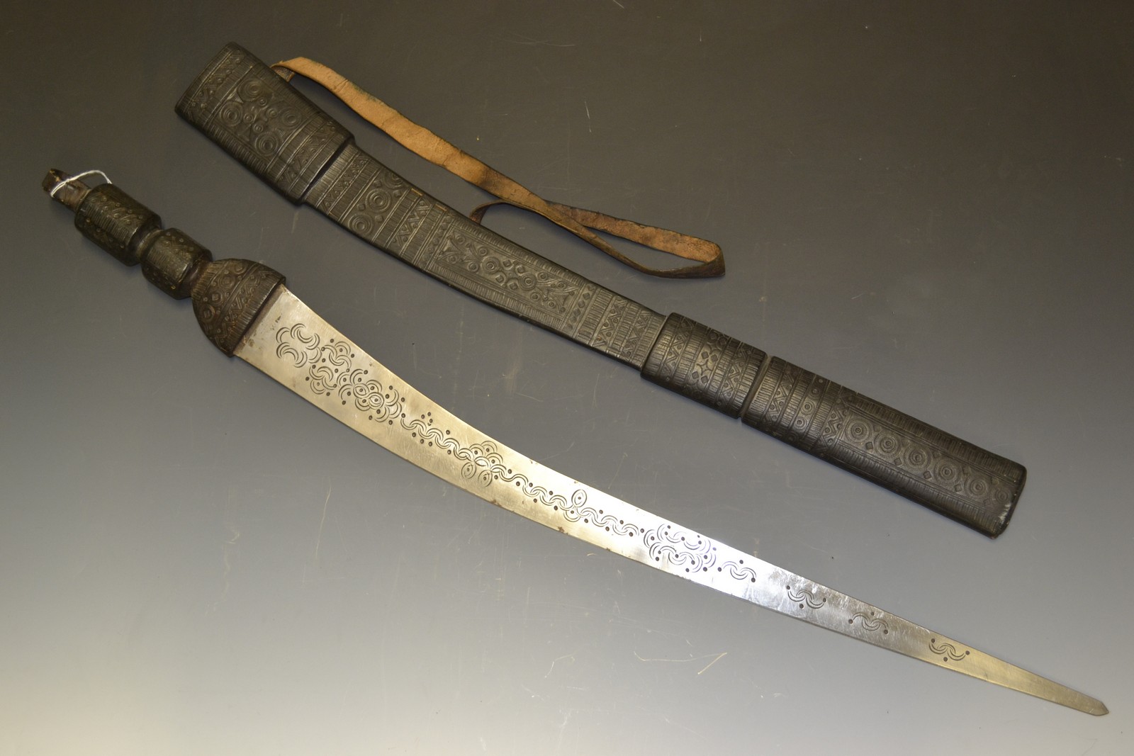 A Sudanese sword, 71cm blade engraved with foliate curves, tooled leather grip and scabbard,