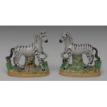 A pair of Staffordshire zebras, to the left and right, the oval bases applied with shredded clay,