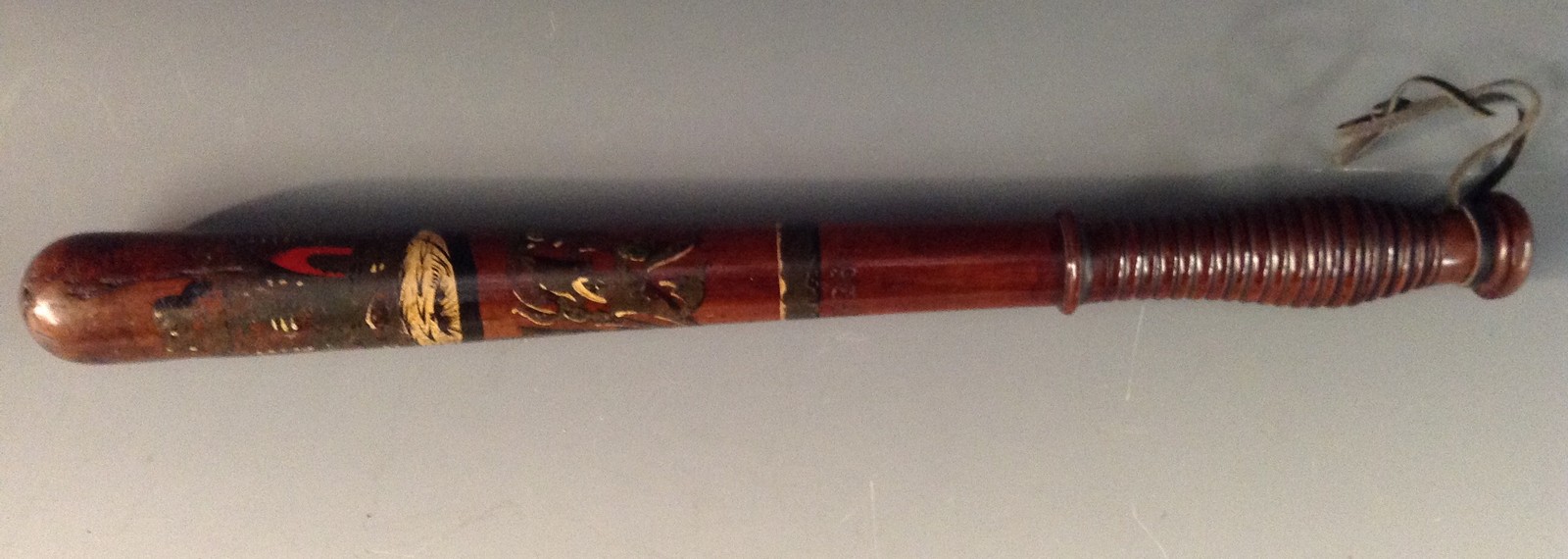 A Victorian turned and painted truncheon, decorated in polychrome with crowned VR cypher, ring grip,