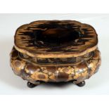 A Japanese lacquer shaped oval stand, decorated in gilt with flowers, butterflies and trellis,