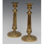 A pair of 19th century gilt metal table candlesticks, detachable nozzles, spreading fluted columns,