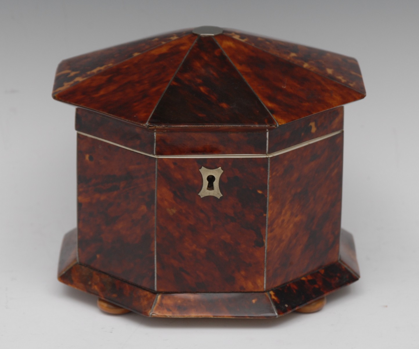 A 19th century tortoiseshell octagonal tea caddy, hinged cover centred by a vacant cartouche,