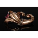 A ruby and diamond cornucopia brooch, arching cornucopia body,