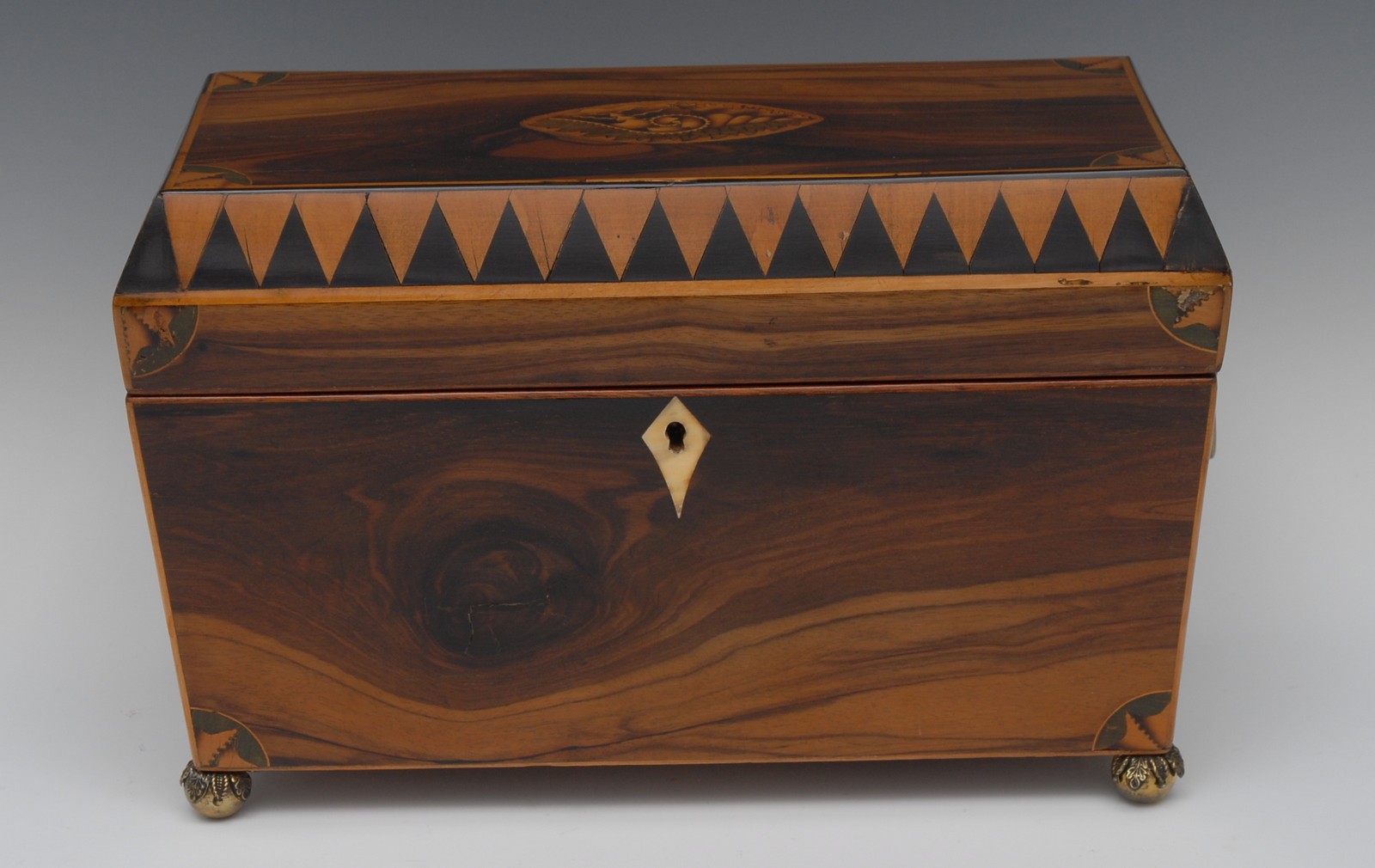 A 19th century sarcophagus walnut tea caddy, the cover inlaid with shell patera,