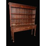 An 18th century oak dresser, the back with moulded cornice above three open shelves,