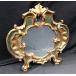 An 18th century carved, parcel-gilt and painted cartouche shaped looking glass,