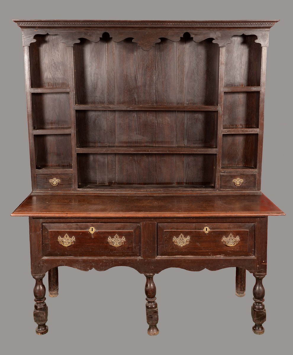 An '18th century' oak dresser, Greek key cornice above a shaped frieze, shelves and small drawers,