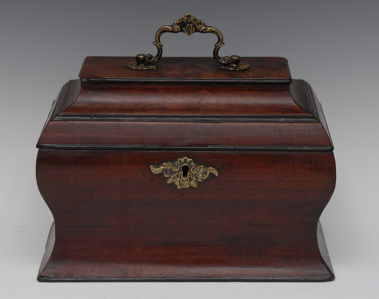 A George II mahogany ogee bombe shaped tea caddy, hinged cover with brass Rococo swan neck handle,