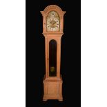 An early 20th century limed oak musical hall clock,