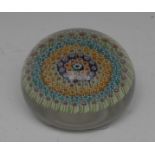 A millefiori paperweight, worked in coloured canes with bands of flowers,