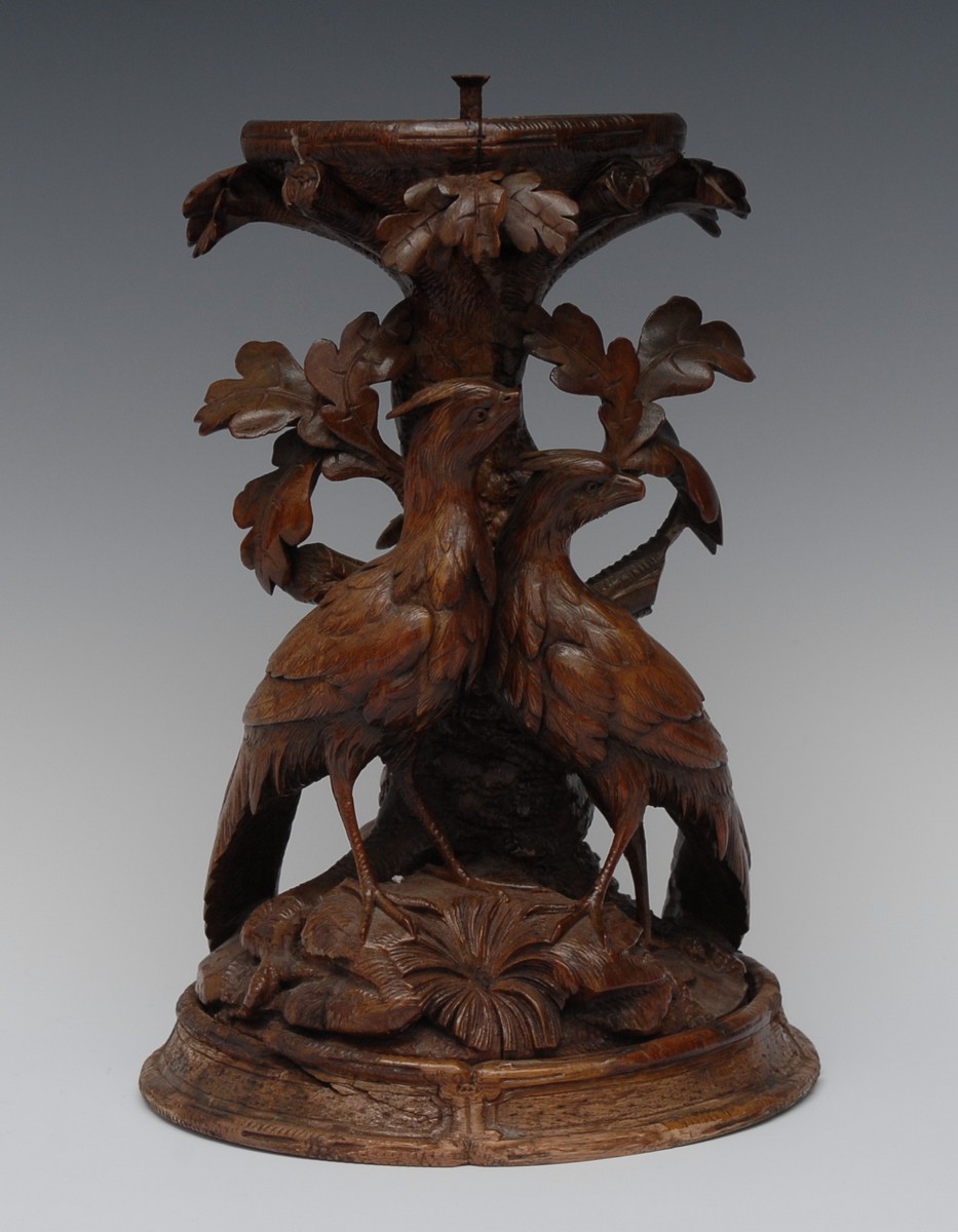 A 19th century Black Forest pedestal, carved with a pair of birds beside a leafy tree,