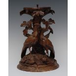 A 19th century Black Forest pedestal, carved with a pair of birds beside a leafy tree,