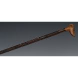 A 19th century gentleman's novelty walking cane, the hardwood pommel carved as the head of a dog,