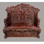 A Chinese hardwood hall bench, shaped arched back boldly carved with ferocious dragons,