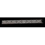 An early 20th century diamond encrusted bracelet, composed of eight alternating Fleur de Lys crests,