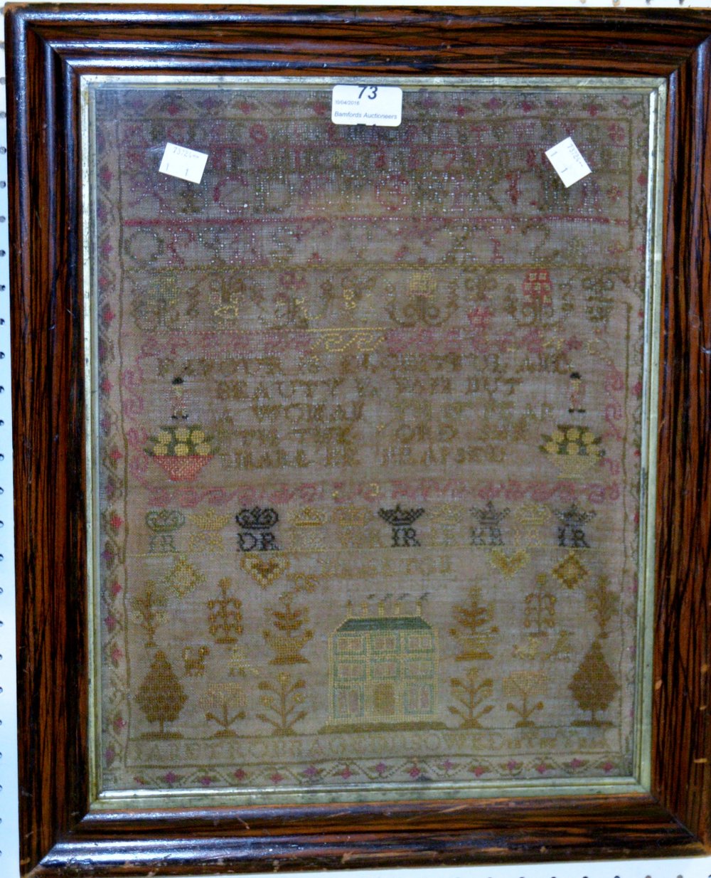 A mid 19th century sampler, embroidered with alphabet, verse and house,
