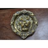 A large brass lion mask door knocker, 23cm diameter.