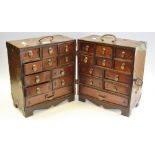 An oriental cabinet in two hinged sections, various size drawers,