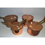 Copper - a set of four graduating saucepans with covers,