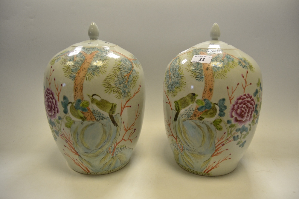 A pair of contemporary Chinese ginger jars and covers decorated with fanciful birds perched on