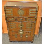 An oriental cabinet, heavily decorated in brass, metal bound, one central cupboard on top,