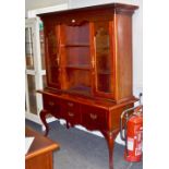 A 20th century dresser, oversailing cornice, glazed top, shaped frieze above two shelves,