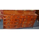 A 20th century sideboard, one large cockbeaded drawer, flanked by two smaller, over six drawers,