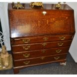 A George III oak fall front bureau, enclosing pigeon holes and drawers, four graduated drawers,