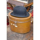 A bowler hat by John C. Badley & Co. in a tin hat box.