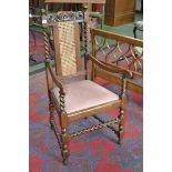 An oak open armchair, knop finials, wickerworked splat, barley twist uprights, drop in seat,
