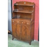 A 19th century mahogany waterfall bookcase cabinet, shaped gallery with flame mahogany cartouche.