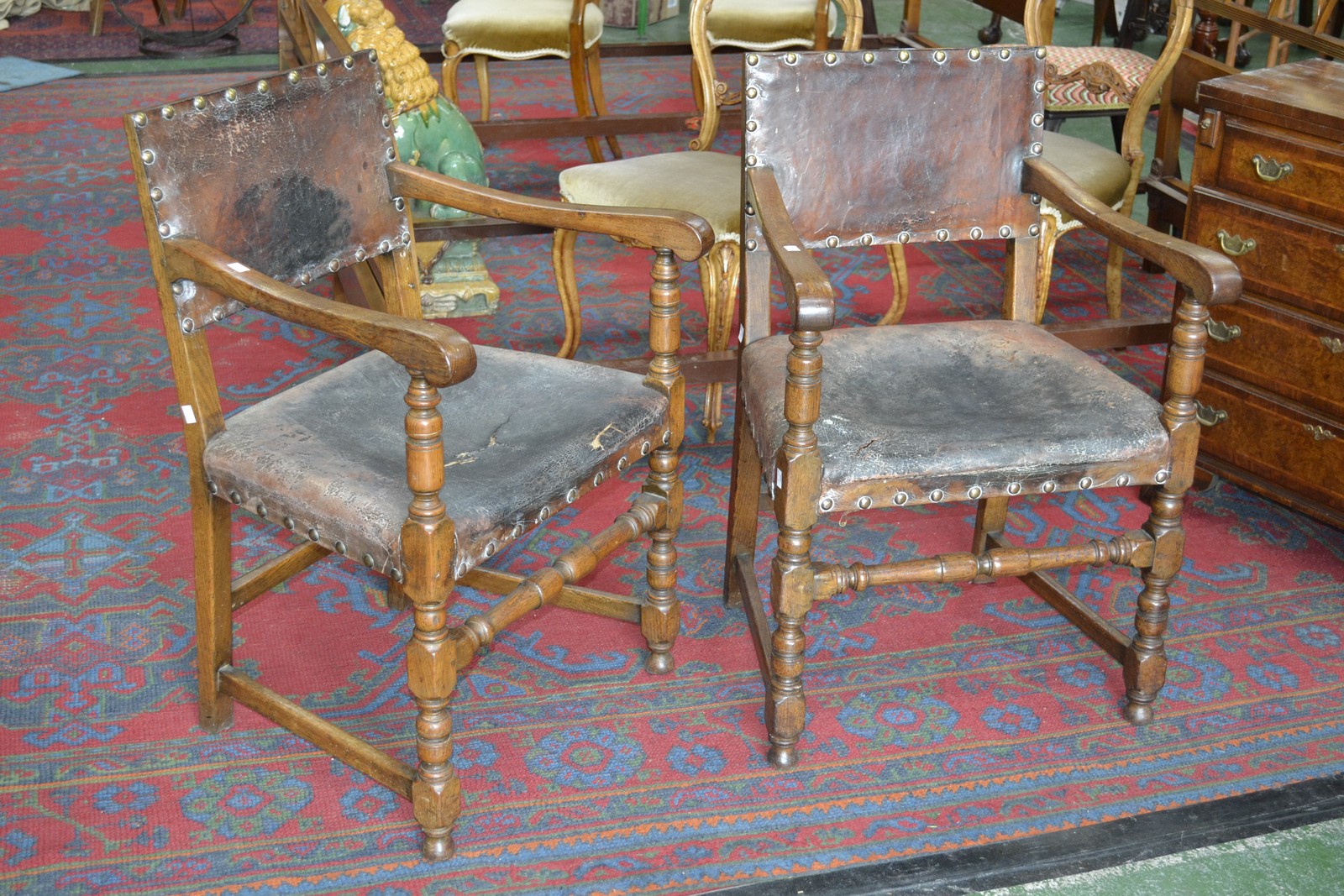 A pair of 17th century style oak armchairs, brass studded tan hide upholstery, c.