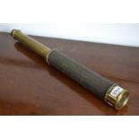 A single drawer brass telescope with woven silk cover.