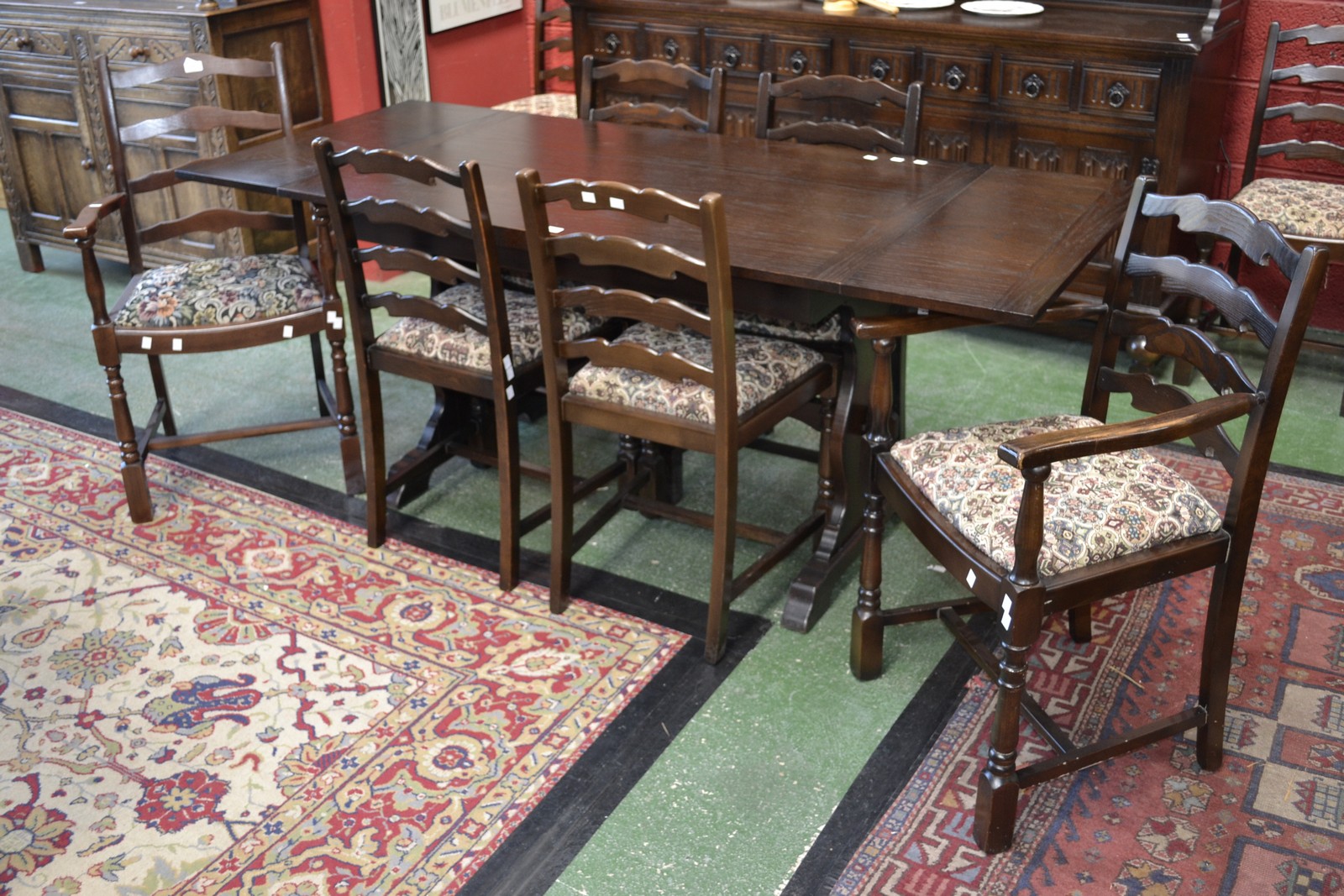 A dark oak drawleaf extending dining table and eight ladder back chairs