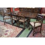 A dark oak drawleaf extending dining table and eight ladder back chairs