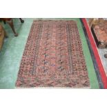 A hand woven eastern rug, geometric design in hues of brown, blue and beige on a brick ground.