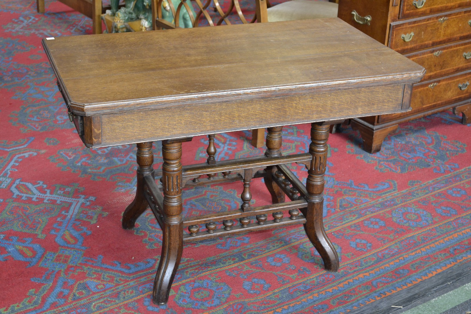 An early 20th century oak card table of large proportions, rectangular top with canted corners,