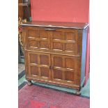 A 1940`s oak drinks cabinet, a fall front door to top, a pair of panelled cupboard doors to base.