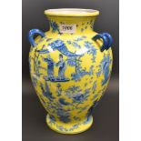 An oriental style baluster vase, transfer printed blue figures on a yellow ground.