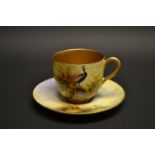 A Royal Worcester coffee can and saucer, signed W H Austen, painted with peacocks,