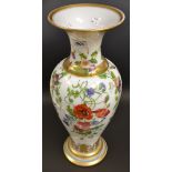 A milk glass vase with hand painted floral embellishment and gilding.