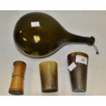 A pair of horn beakers; a dark green flask bottle;