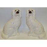A pair of late 19th Century Staffordshire dogs, seated to the left and right,