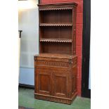 An oak bureau bookcase, outswept cornice, two shelves with shaped skirts to top, projecting base,