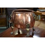 A copper and brass cauldron, lion mask handles,