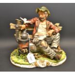 A Capodimonte figure of a contented vagrant, seated on a bench by a stove,