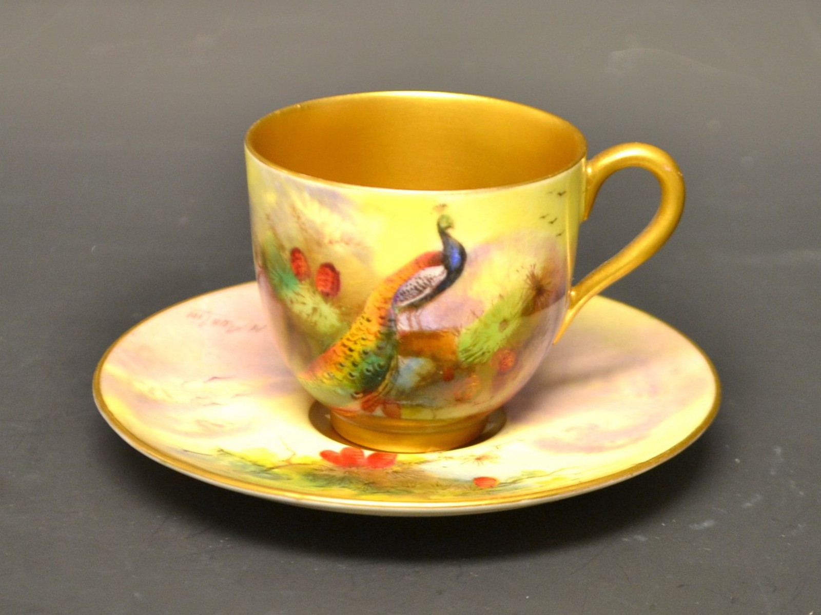 A Royal Worcester coffee can and saucer, signed R Austen, painted with peacocks,